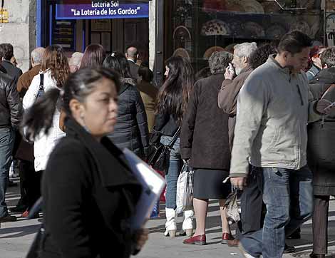 Decenas de personas esperan su turno ante una administracin de lotera de la Puerta del Sol. | Efe