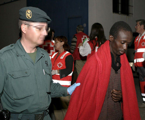 Un Guardia Civil acompa a un inmigrante recin llegado en una patera. | Efe