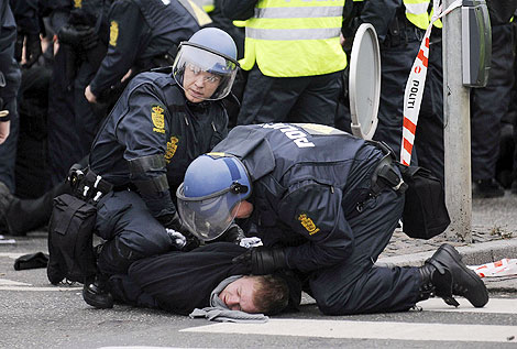 Dos policas inmovilizan a un manifestante. | Efe