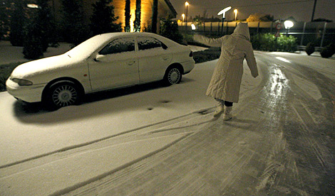 Una mujer intenta caminar entre la nieve en la capital. | Efe