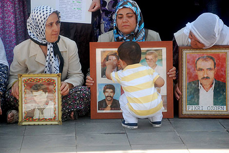 varias madres kurdas con las fotos de sus allegados.