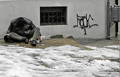 Un indigente en una calle nevada en Len. | Javier Gutirrez