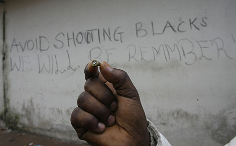 Un inmigrante muestra una bala junto a la fbrica donde vive. | Afp