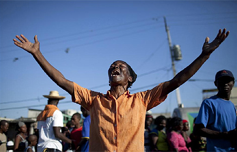 Una mujer clama al cielo en las calles de Puerto Prncipe, Hait. (Foto: Reuters)