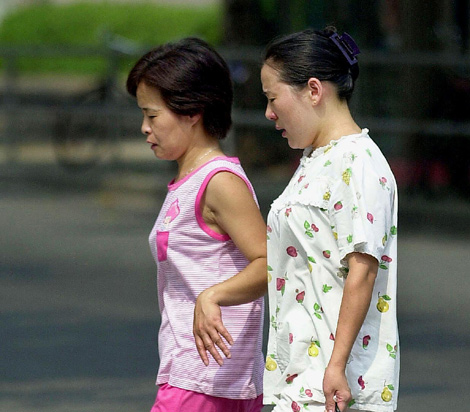Dos mujeres pasean en pijama por las calles de Shanghi en 2002. | Archivo