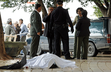 Vecinos y agentes de la Policía junto al cadáver. | C. Díaz