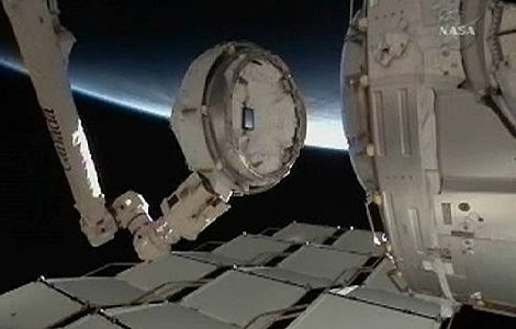 El brazo robtico durante la instalacin del mdulo con la cpula acristalada en la ISS. | NASA