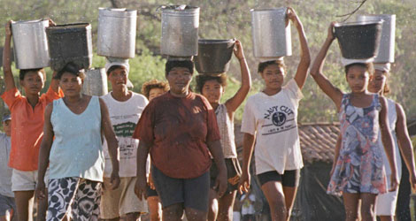 Un grupo de mujeres recoge agua con cubos en Brasil. | Ap