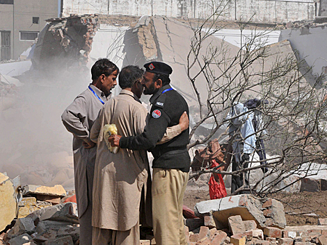 Un polica consuela a afectados por las explosiones en Lahore. | Efe