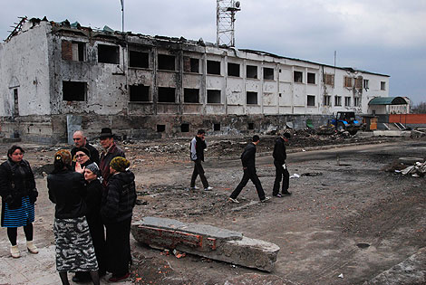 Varias personas en Nazran, ante los restos de un edificio policial atacado el año pasado. | AFP