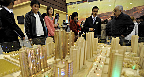 Varios agentes inmobiliarios se afanan por vender en la feria de Qingdao. | Efe