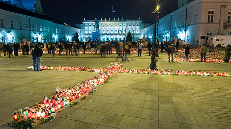 Flores y velas colocadas en forma de cruz depositadas a las puertas del Palacio Presidencial. | Foto: Efe