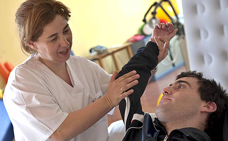 Una enfermera ayuda a Ivn a hacer sus ejercicios en el Centro de Referencia Estatal de Enfermedades Raras de Burgos . | Ical