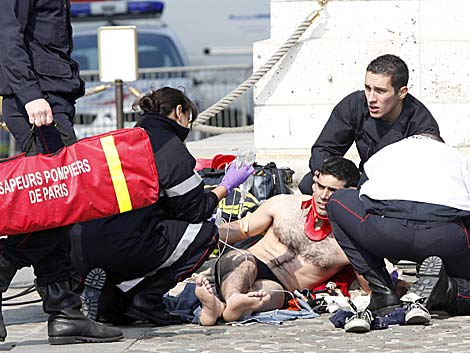Personal sanitario atiende a la persona herida tras caer del monumento. | AFP