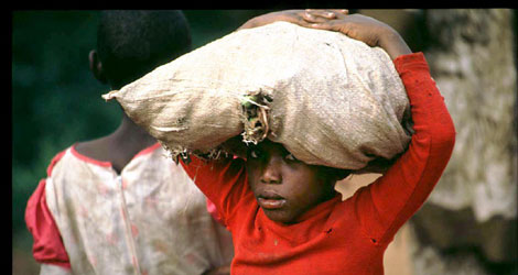 Un niño trabaja transportando sacos de comida, en Ruanda. | A.Raffaele Ciriello