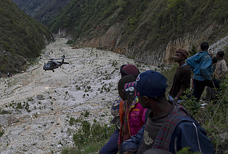 Un grupo de haitianos observa a un helicptero de EEUU que trabaja en el rescate. Ap