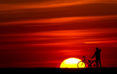 Un ciclista disfruta de la puesta de sol en una pradera de Frncfort del der (Alemania). | Efe