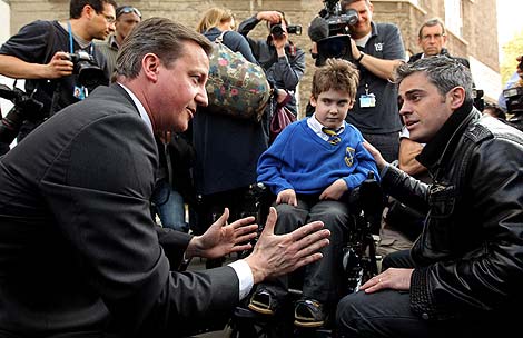 David Cameron habla con el padre de un nio discapacitado. | Afp