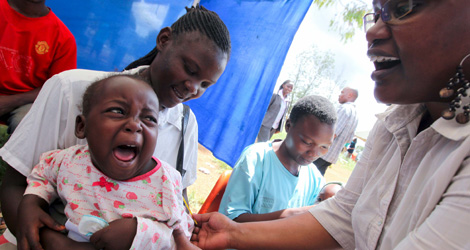 Una nia llora mientras una doctora le hace unas pruebas de malaria. | Efe