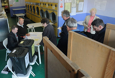 Un grupo de personas deposita su voto en una lavandera de Oxford. | Reuters