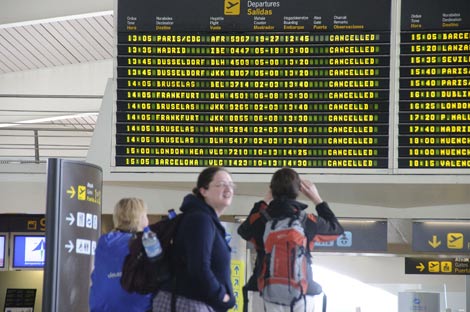 Varios viajeros comprueban la cancelacin de sus vuelos en el aeropuerto de Loiu. | P. Corral