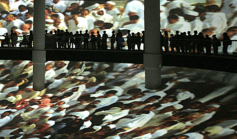 Visitantes sobre la gigantesca pantalla del Pabelln Saud.
