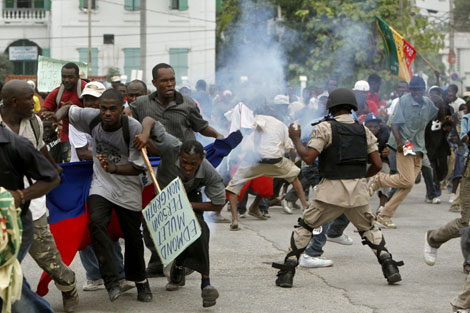 La gente huye del gas que lanza la polica durante una protesta contra Rene Preval. | Ap