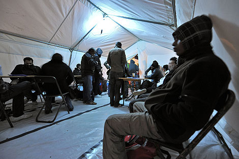 Personas sin hogar esperan una cama para pasar la noche | Afp