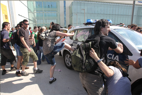 Los activistas atacan a un coche de la polica. | Jos Aym
