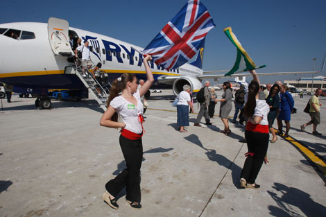 Una panda de verdiales con la bandera inglesa recibe a los pasajeros. | A. Pastor