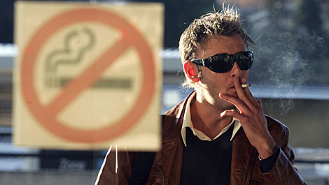 Un hombre apura su cigarro a las puertas de un local donde se prohbe fumar. | Efe