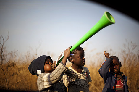 Unos nios tocan la vuvuzela en las afueras de Johannesburgo. | Emilio Morenatti