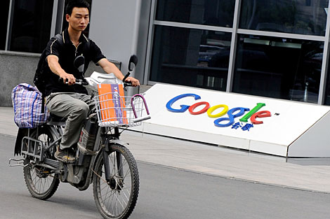 Un hombre pasa en motocicleta ante la sede de Google en China. | AFP