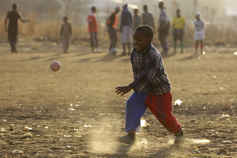 Nios jugando al ftbol en un barrio de Soweto. | Ap