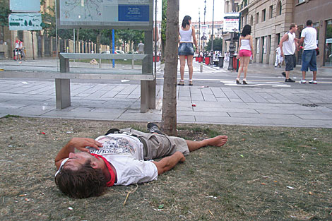 Un joven duerme en un jardn de Pamplona durante el ltimo encierro de los Sanfermines. | M.I.