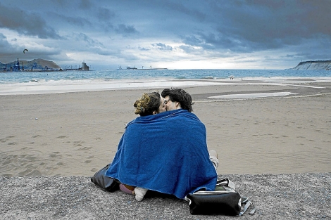 Una pareja se besa en la playa de Ereaga en Getxo. | Carlos García