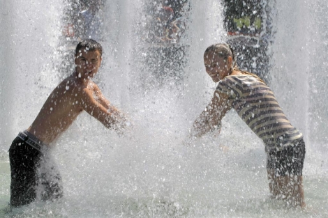Dos jóvenes se refrescan en un fuente en Moscú. | Ap