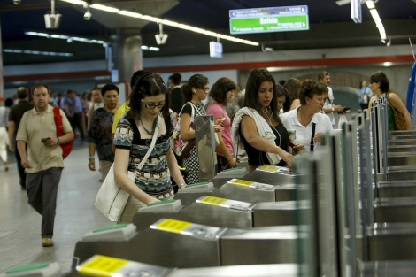 Varios ciudadanos entren en el metro. | Efe