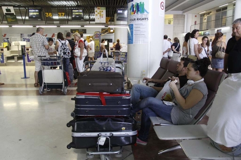 Dos pasajeros esperan la salida de su vuelo en el aeropuerto de El Altet. | Roberto Pérez