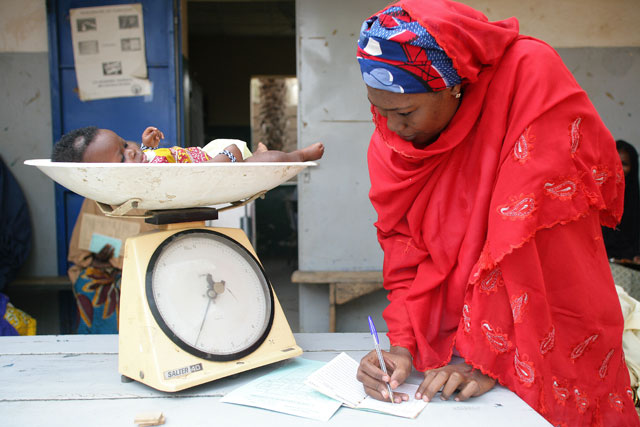 Una mujer toma nota del peso de un bebé en Níger. | Unicef