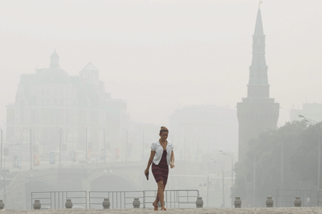 Una mujer camina entre el manto de humo que cubre Mosc. | Efe