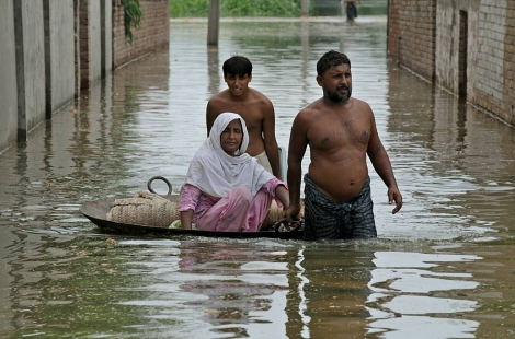Tres supervivientes de las inundaciones abandonan sus hogares. | AFP
