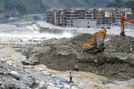 Las excavadoras cavan un canal por fuertes lluvias, que han provocado deslizamientos de tierra, condado de Wenchuan, China. | Efe