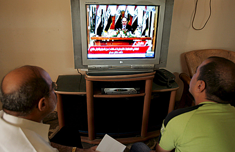 Dos iraques escuchan el discurso televisado del premier Nuri al Maliki. | Efe