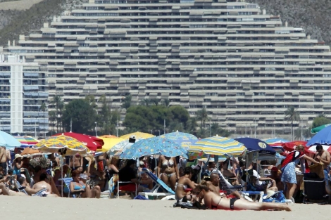 Veraneantes en la playa de Cullera, flanqueada de apartamentos tursticos. | Elmundo.es