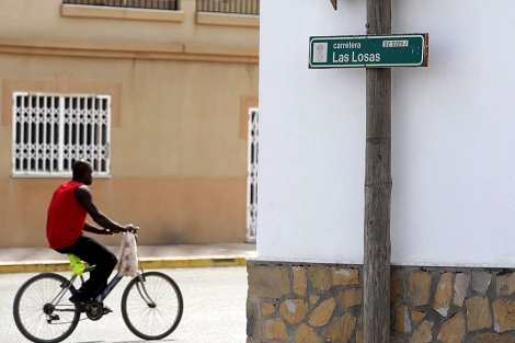 Un africano pasea en bici por el Camino de Las Losas en Roquetas de Mar. | Efe