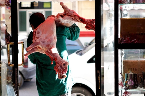Un carnicero transporta un cordero sacrificado orientado a la Meca. | Efe