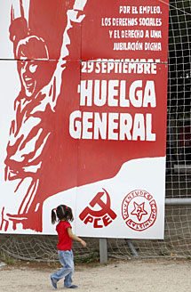 Una nia observa un cartel del PCE promoviendo la huelga. | Efe
