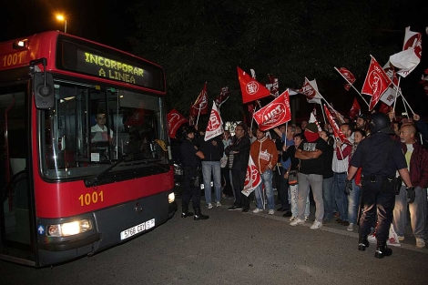 Un autobs urbano de Sevilla echa a andar custodiado por la polica. | Fernando Ruso