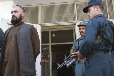 Oficiales afganos escoltan a un supuesto comandante talibn en Afganistn. | Efe
